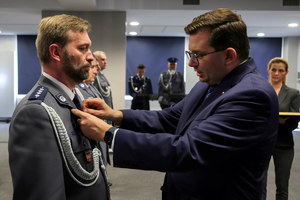 wojewoda przypina medal policjantowi