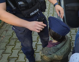 policjant zakłada dziecku służbową czapkę