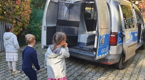 troje dzieci ogląda wnętrze radiowozu