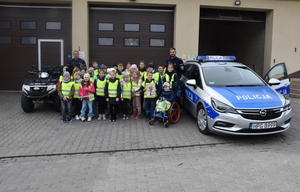Zdjęcie grupowe uczniów biorących udział w prelekcji oraz policantów. Na zdjęciu oznakowany policyjny radiowóz i quad