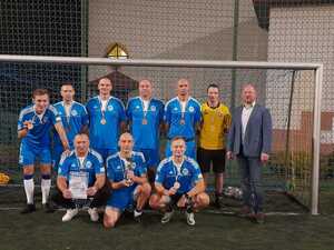 drużyna policjantów w niebieskich strojach z Komendantem Powiatowym