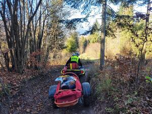 gopr wiezie poszkodowanego drogą leśną