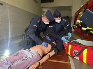 policjanci pochylający się nad fantomem podczas ćwiczeń z udzielania pierwszej pomocy