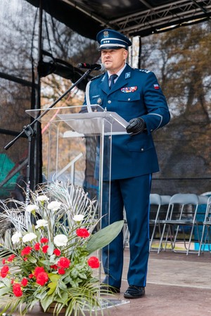 Komendant Powiatowy Policji w Brzesku stojący na scenie i przemawiający do uczestników pikniku