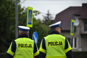 Dwóch policjantów ruchu drogowego nadzoruje ruch w rejonie przejścia dla pieszych