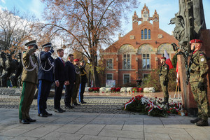 Delegacja wojewody z komendantem wojewódzkim stoi przed pomnikiem Józefa Piłsudskiego