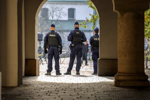 Policjanci na placu Studzińskiego zabezpieczają przejście. Widok z tyłu