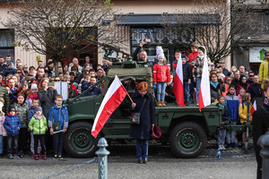 Dzieci z flagami na wojskowym samochodzie