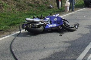 Motocykl leżący na jezdni po wypadku