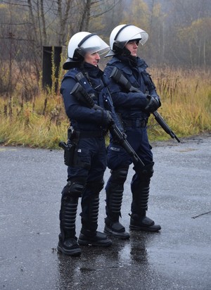 dwóch policjantów w strojach PZ i bronią gładkolufową