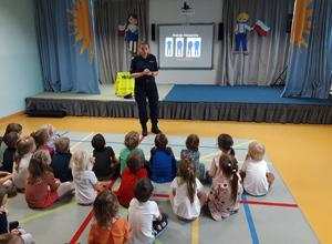 policjantka w sali przedszkola prowadzi zajęcia dla grupy dzieci