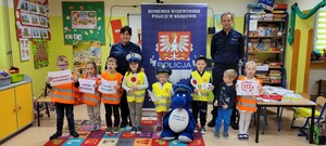 grupa przedszkolaków z policjantami i maskotką policyjną na pamiątkowej fotografii