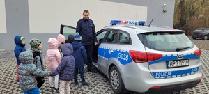 przedszkolaki wraz z policjantem podczas pokazu radiowozu z policyjnego