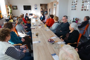 siedzacy przy stole seniorzy wysłuchują rozmowy pracownicy zus