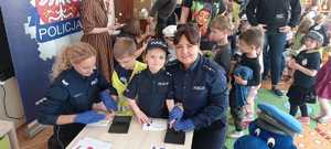 policjantki wraz z dziećmi podczas wykonywania odcisków linii papilarnych