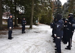 naczelnicy pionu prewencji podsumowują ćwiczenia - dwóch naczelników stoi przed grupą policjantów