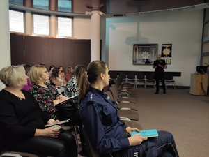 Podinspektor Wojciech Chechelski prowadzi spotkanie z pedagogami w auli olkuskiej komendy. W tle na ściśnie sztandar komendy