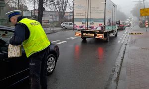 „Bezpieczny przejazd. Szlaban na ryzyko” akcja w Mikołajki 2022  policjant przy samochodzie