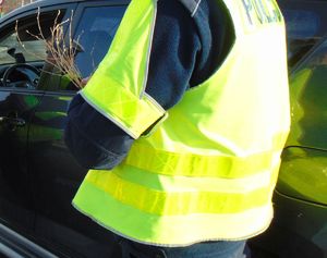 „Bezpieczny przejazd. Szlaban na ryzyko” akcja w Mikołajki 2022  policjant trzyma w dłoni rózgi