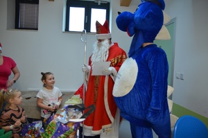 dwie dziewczynki trzymając w ręku prezenty rozmawiają z Mikołajem i Inspektorem Wawelkiem