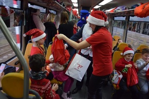 pracownicy Polregio w towarzystwie Inspektora Wawelka rozdają prezenty dzieciom w waganie pociągu