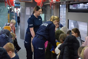 dwie policjantki w pociągu częstują dzieci cukierkami