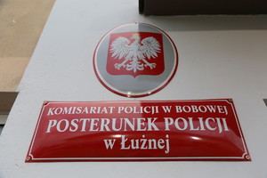 tabliczka z napisem Posterunek Policji w Łużnej wiszący na ścianach budynku