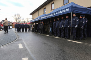 policjanci stojący pod namiotami ochronnymi z napisem Komenda Powiatowa Policji w Gorlicach