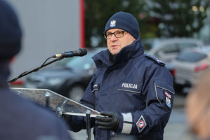 przemawiający przy mównicy policjant