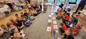przedszkolaki siedzą na dywanie podczas zajęc profilaktycznych