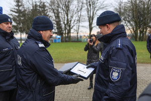 Komendant Augutyniak przekazuje kierownikowi posterunku symboliczny klucz