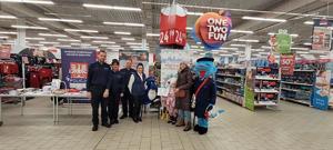 policjanci wraz z przedstawicielką Auchan, klientami na pamiątkowym zdjęciu podczas akcji Bezpieczne zakupy