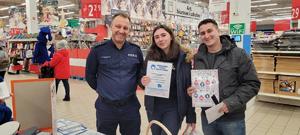 policjant wraz z klientami Auchan podczas akcji Bezpieczne zakupy