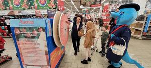 przedstawicielka Auchan Kraków wraz z dziećmi i Polisią podczas zabawy Koło zagadek na akcji Bezpieczne zakupy