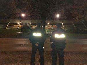 Zabezpieczenie Pucharu Polski 2022 w Hokeju na lodzie policjanci stoją przy ulicy w tle hala lodowa