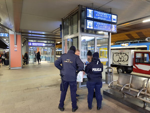 funkcjonariusze rozmwaiją z dwoma osobami na jednym z peronów krakowskiego dworca kolejowego