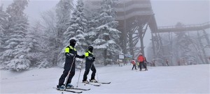 patrol narciarski na stoku, w tle wieża widokowa