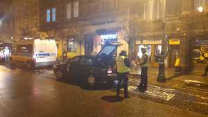 zdj. pora nocna, jedna z krakowskich ulic, dwaj policjanci Ruchu Drogowego kontrolują samochód taxi