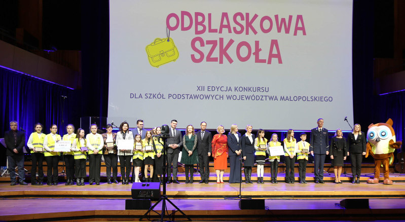 Na scenie stoją uczniowie z nagrodami oraz osoby wręczające. Na ekranie napis Odblaskowa Szkoła