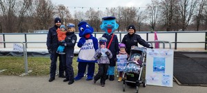 dzieci wraz z policjantami i maskotkami policyjnymi na pamiątkowym zdjęciu przed lodowiskiem TAURON Areny Kraków