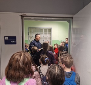 policjant rozmawia z dziećmi przed wejściem do pPDOZ