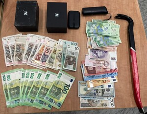 ułożone banknoty euro i polskiej waluty na stole, obok łom, nad nimi gaz łzawiący w futerale i trzy pudełka