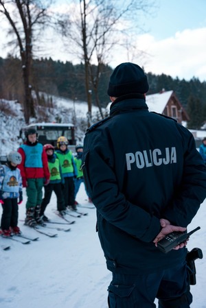 Policjant oraz narciarze biorący udział w konkursie