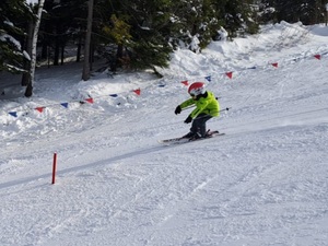 dziecko jedzie na nartach po torze przeszkód