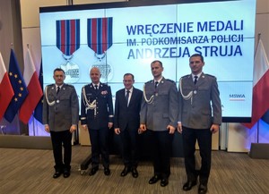 Trzech nagrodzonych policjantów na wspólnym zdjęciu z ministrem spraw wewnętrznych i komendantem głównym policji