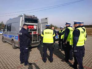 policjanci dąbrowskiej drogówki w kamizelkach odblaskowych, wyposarzenie radiowozu tzw. wypadkowej