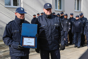 Komendant wojewódzki wraz z komendantem komisariatu pozują do zdjęcia z symbolicznym kluczem