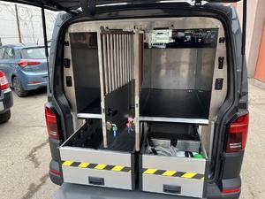 otwarty bagażnik i dwie klatki przystosowane do przewozu psów  w nowym VW transporterze
