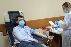 mężczyzna w trakcie oddawania krwi, obok pracownica z punktu poboru krwi