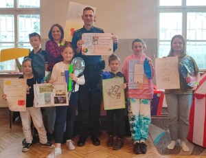 mł. asp. Sebastinan Kruk razem z laureatami konkursu prezentuje prace